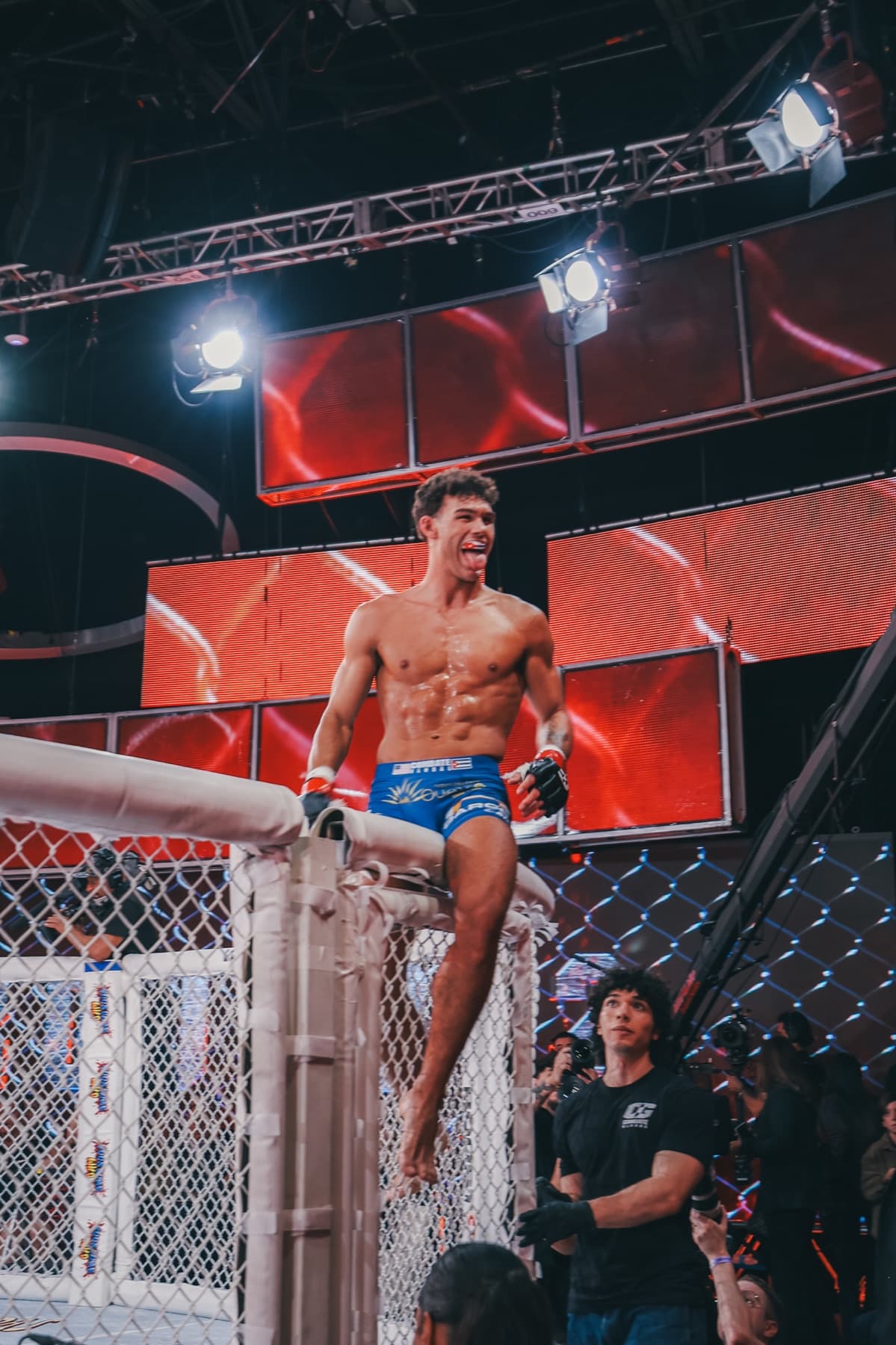 MMA fighter celebrating atop cage
